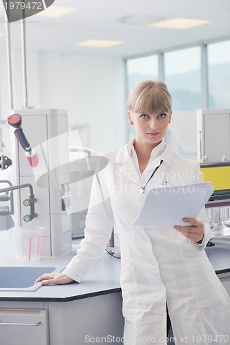 Image of female researcher holding up a test tube in lab