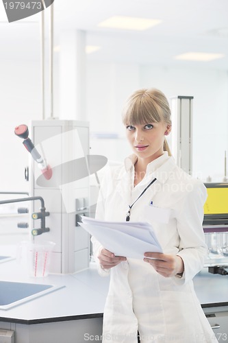 Image of female researcher holding up a test tube in lab