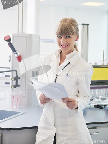 Image of female researcher holding up a test tube in lab