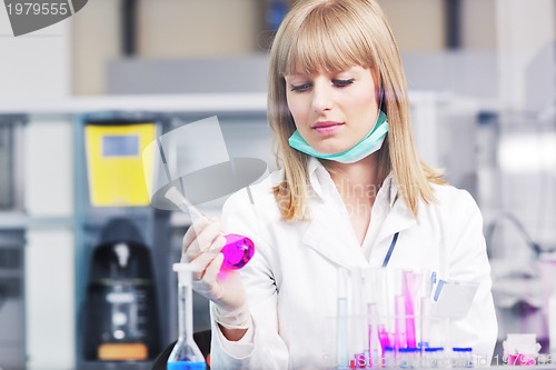 Image of female researcher holding up a test tube in lab