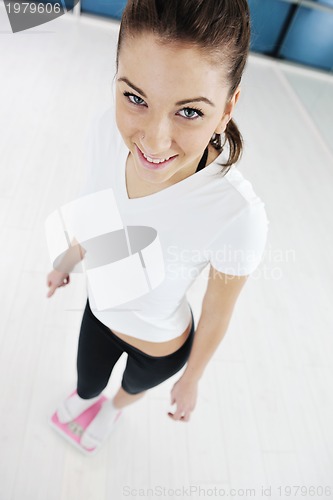 Image of happy diet concept with young woman on pink scale