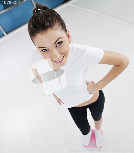 Image of happy diet concept with young woman on pink scale