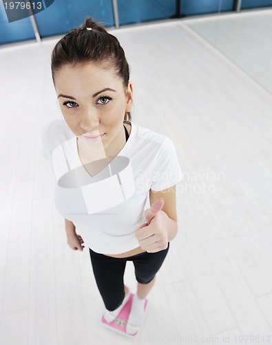 Image of happy diet concept with young woman on pink scale