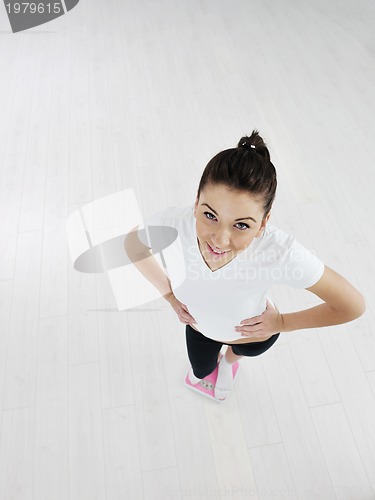 Image of happy diet concept with young woman on pink scale