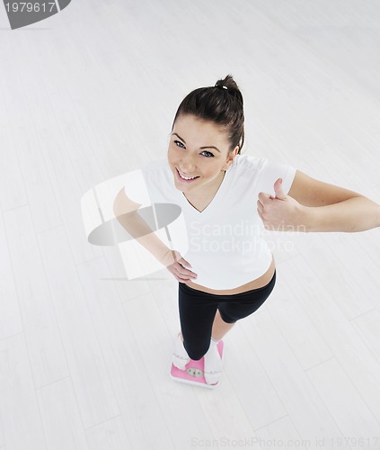 Image of happy diet concept with young woman on pink scale