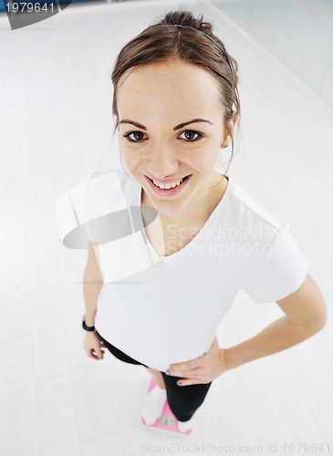 Image of happy diet concept with young woman on pink scale