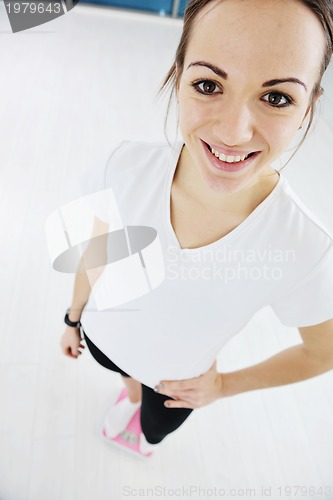 Image of happy diet concept with young woman on pink scale