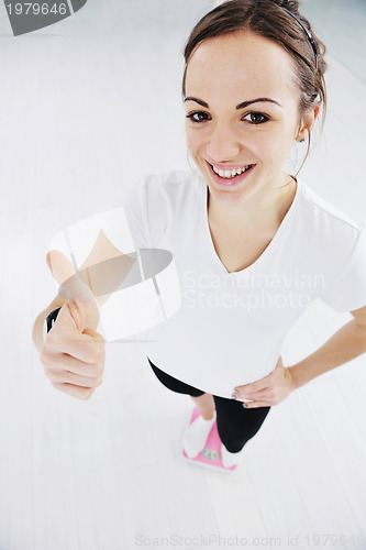 Image of happy diet concept with young woman on pink scale