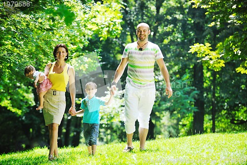 Image of happy young couple with their children have fun at park