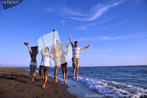 Image of people group running on the beach