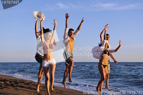 Image of people group running on the beach