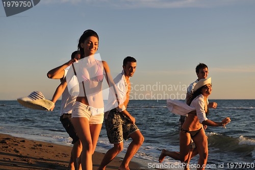 Image of people group running on the beach