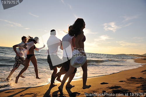 Image of people group running on the beach