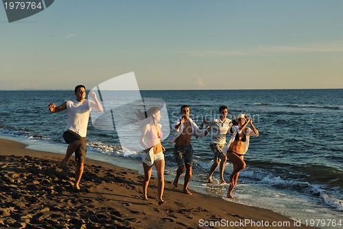 Image of people group running on the beach