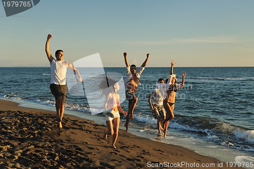 Image of people group running on the beach