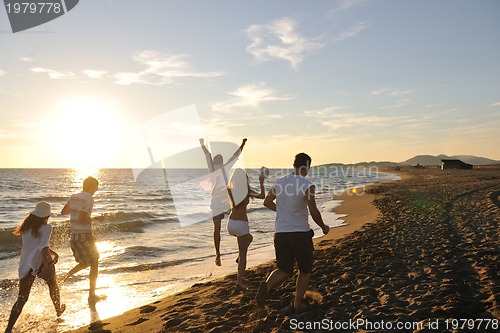 Image of people group running on the beach