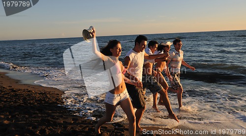 Image of people group running on the beach