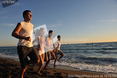 Image of people group running on the beach