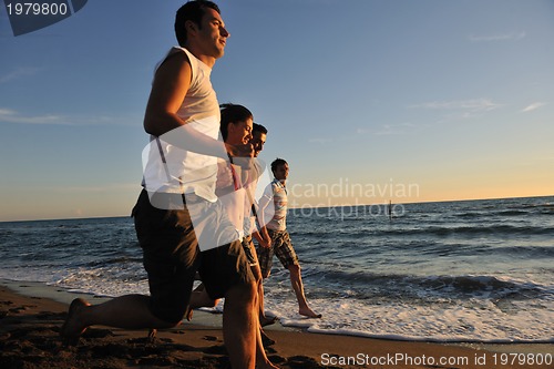 Image of people group running on the beach
