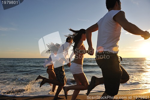 Image of people group running on the beach