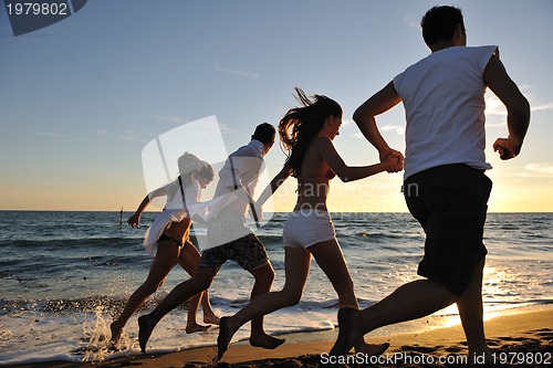 Image of people group running on the beach