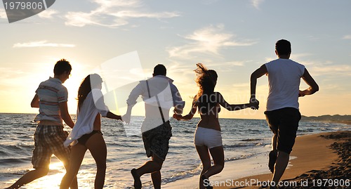 Image of people group running on the beach