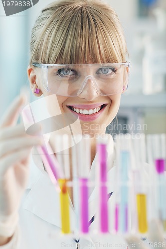 Image of female researcher holding up a test tube in lab