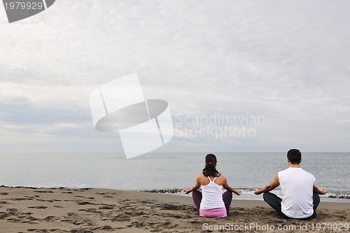 Image of couple yoga beach