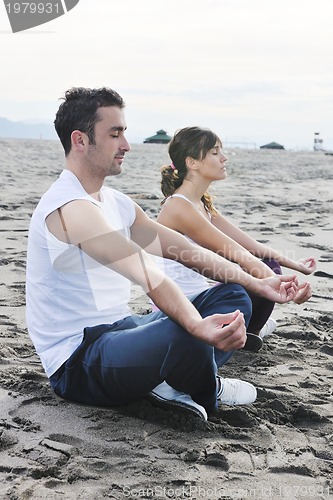 Image of couple yoga beach