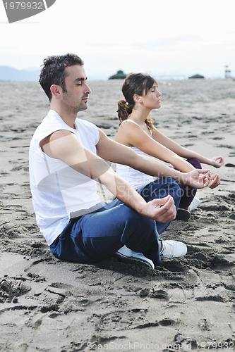 Image of couple yoga beach