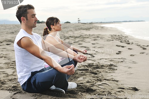 Image of couple yoga beach