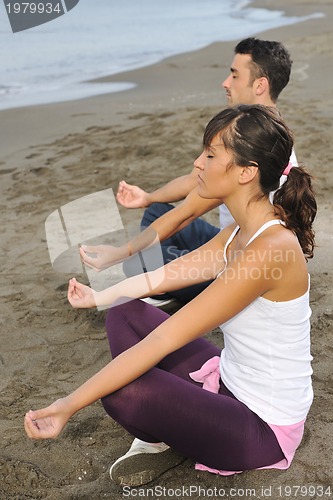 Image of couple yoga beach