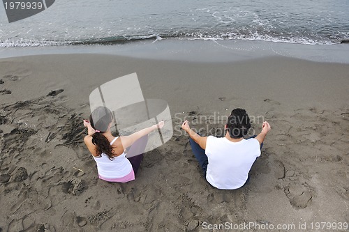 Image of couple yoga beach