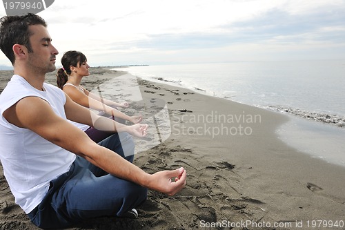 Image of couple yoga beach