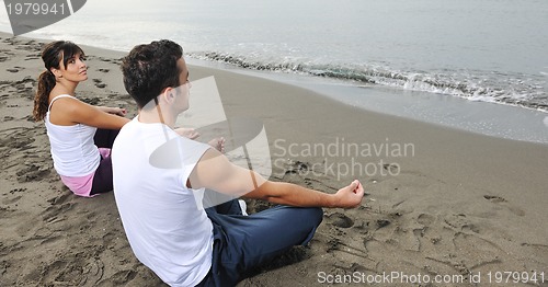 Image of couple yoga beach