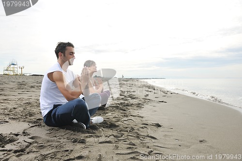 Image of couple yoga beach