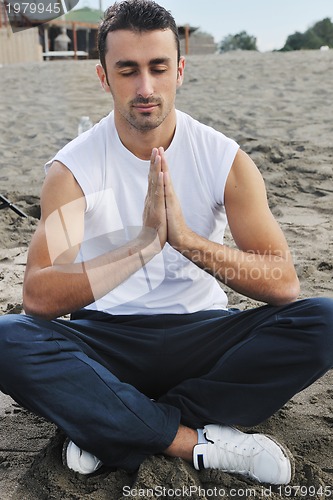 Image of man yoga beach