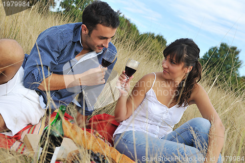 Image of happy couple enjoying countryside picnic in long grass