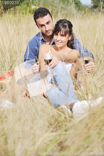 Image of happy couple enjoying countryside picnic in long grass
