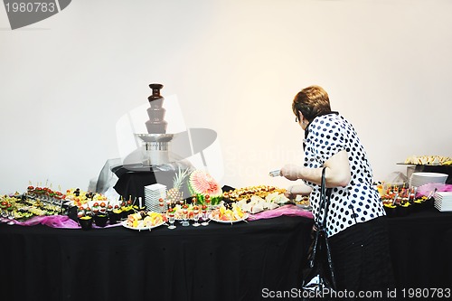 Image of womanl chooses tasty meal in buffet at hotel