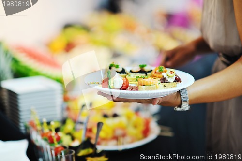 Image of womanl chooses tasty meal in buffet at hotel