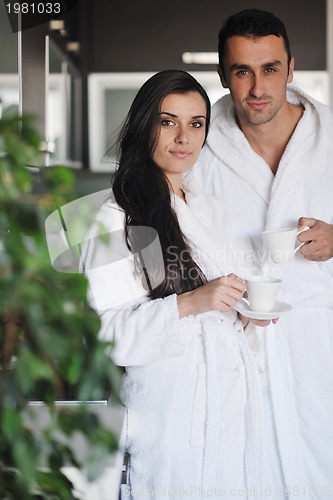 Image of Young love couple taking fresh morning cup of coffee