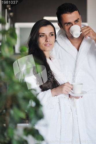 Image of Young love couple taking fresh morning cup of coffee