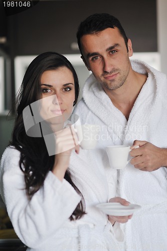 Image of Young love couple taking fresh morning cup of coffee