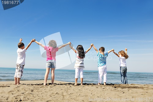 Image of happy child group playing  on beach