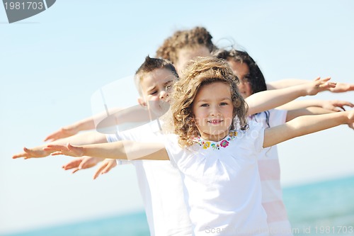 Image of happy child group playing  on beach