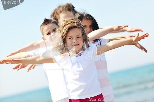 Image of happy child group playing  on beach