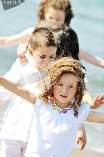 Image of happy child group playing  on beach