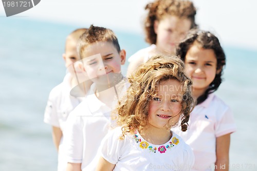 Image of happy child group playing  on beach