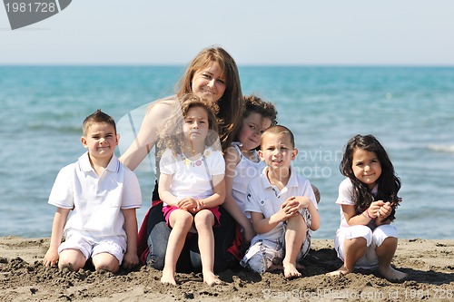 Image of group portrait of childrens with teacher on beach
